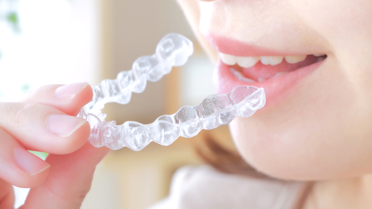 練習用マウスピースを装着して使用感を確かめる様子