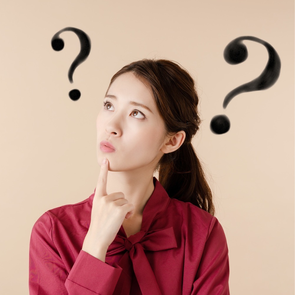 矯正費用について頭に「？」が浮かぶ女性の写真