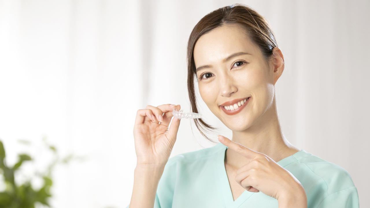 練習用マウスピースを手に持っている女性