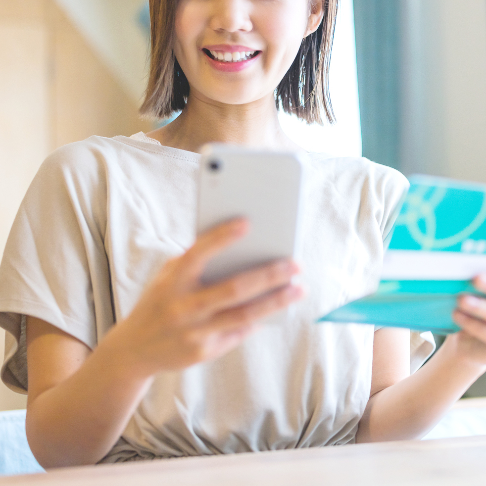 デンタルローンの支払い金額を確認する20代女性