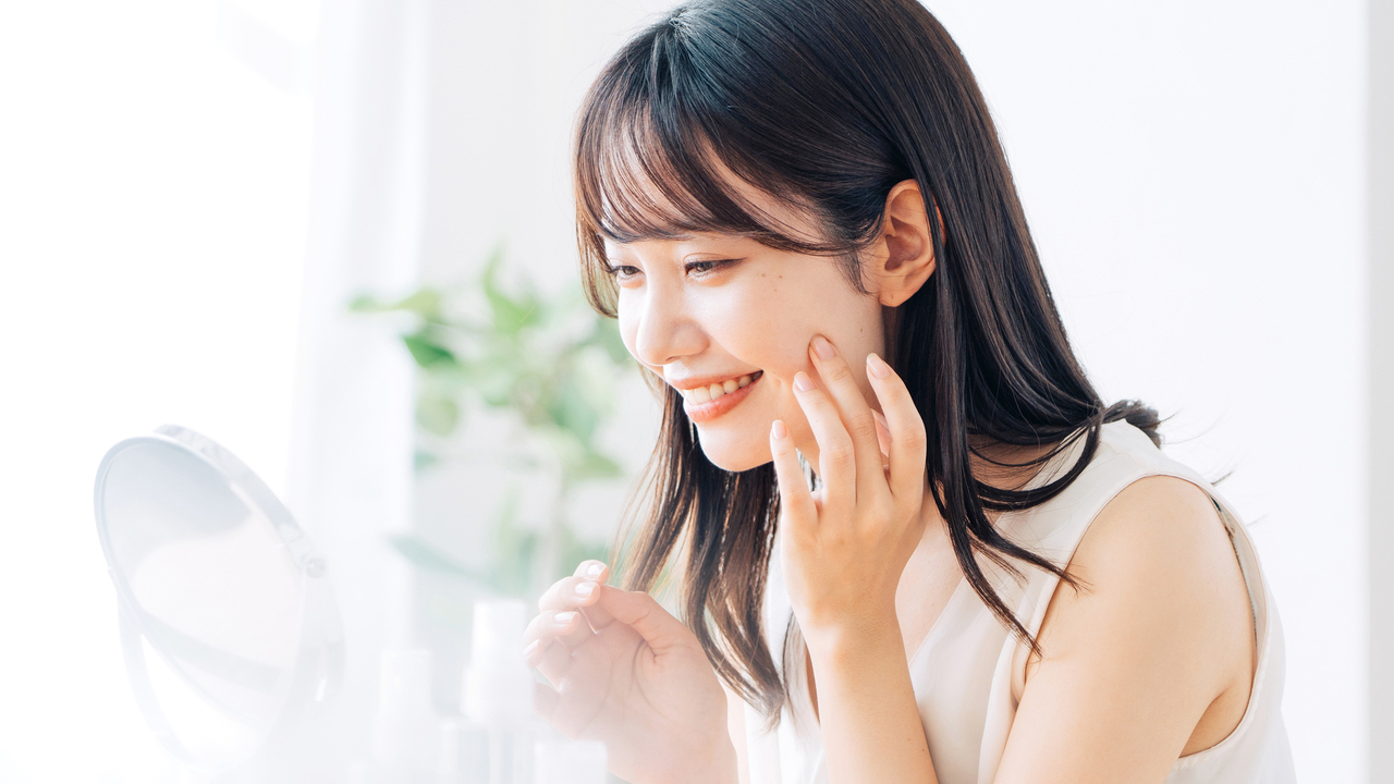 前歯の歯並びがキレイになったか鏡で見る女性