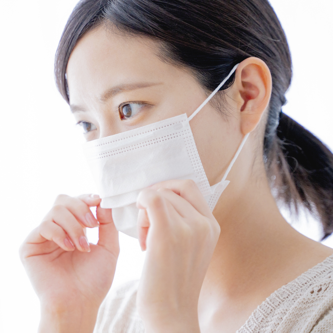 マスクでオープンバイトの口を隠す女性の写真