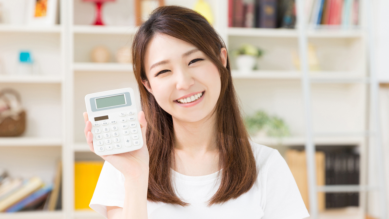 電卓を持って矯正費用を計算している女性