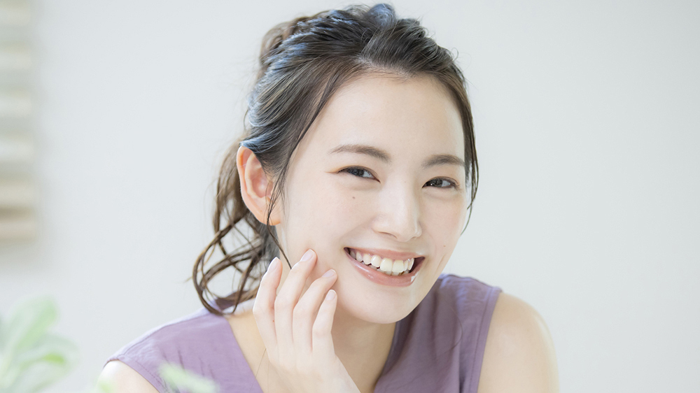 歯科医院でのクリーニングによって歯の着色汚れを防ぐ女性