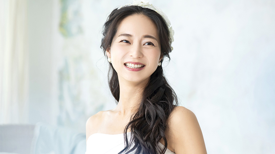 ウェディングドレスを着て笑顔を見せる女性