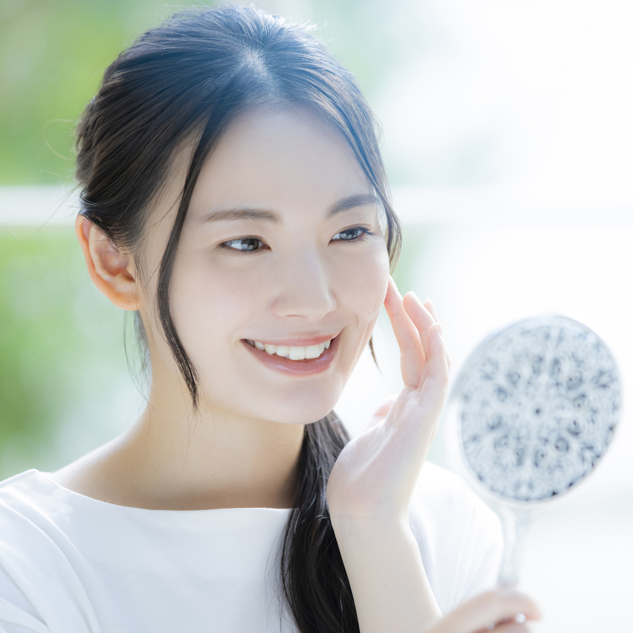 鏡で口を確認する女性の写真