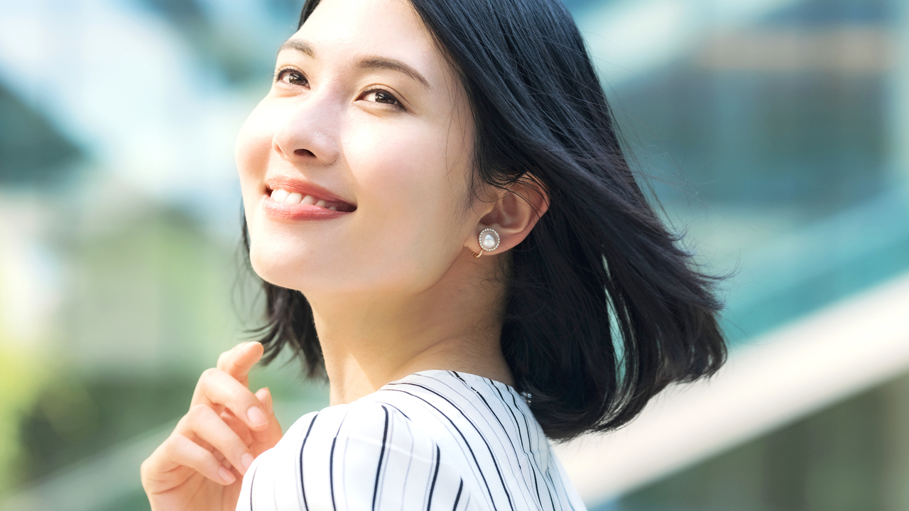 晴れた笑顔で上を向く女性