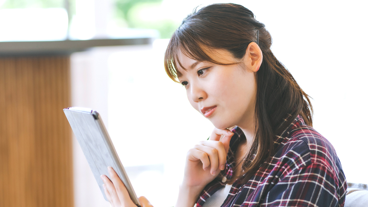 インターネットで矯正歯科の口コミを調べる女性]